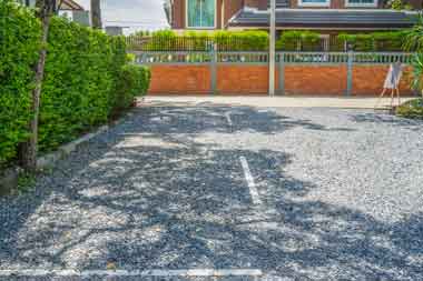 Gravel driveway with striped paving lines in a parking lot