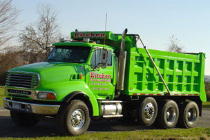 Green Dumptruck Hauling Material For Trucking Services